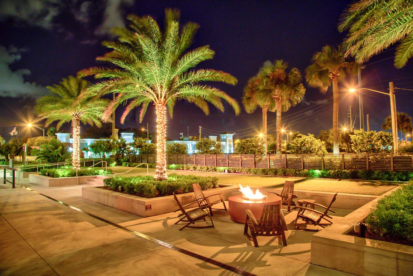 Firepit area and lighted palms at night